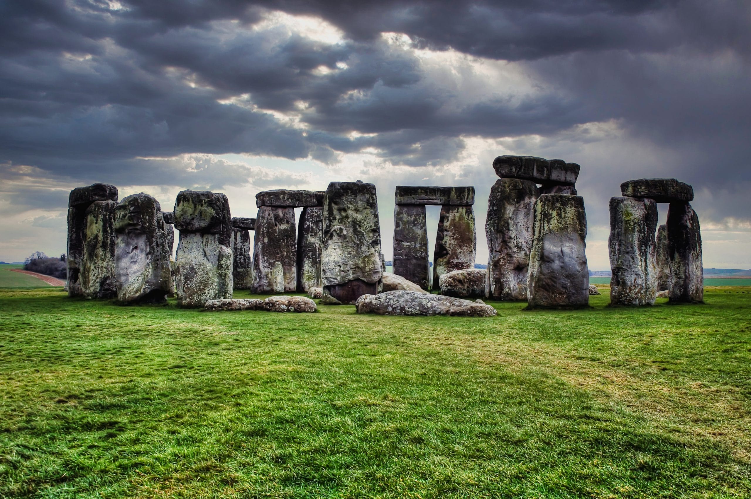 A high contrast shot of the Stonehenge stones in Sailsbury, UK, on cloudy, rainy day with green grass