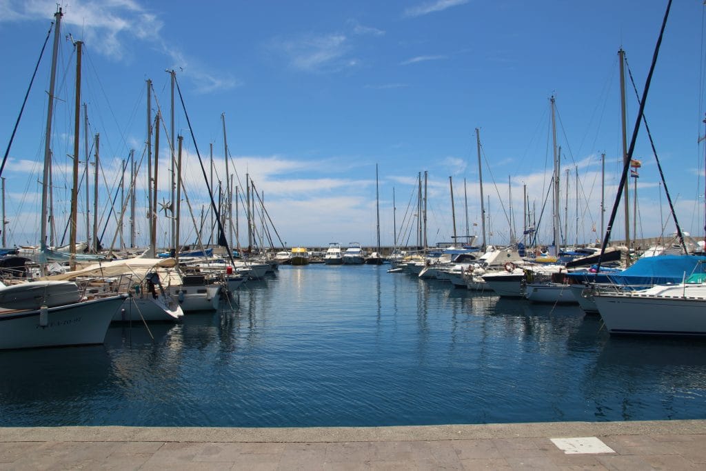 The private boats parked in the port under the pure blue sky