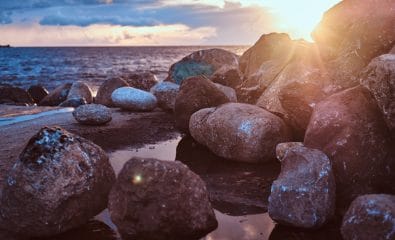 Beautiful seaside with stones, against the background of an amazing bright sunset.